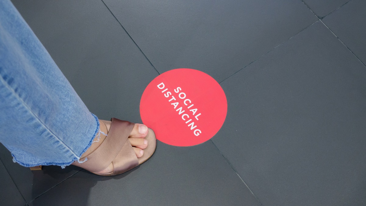 Red sign on ground, remind people to keep distance from each oth